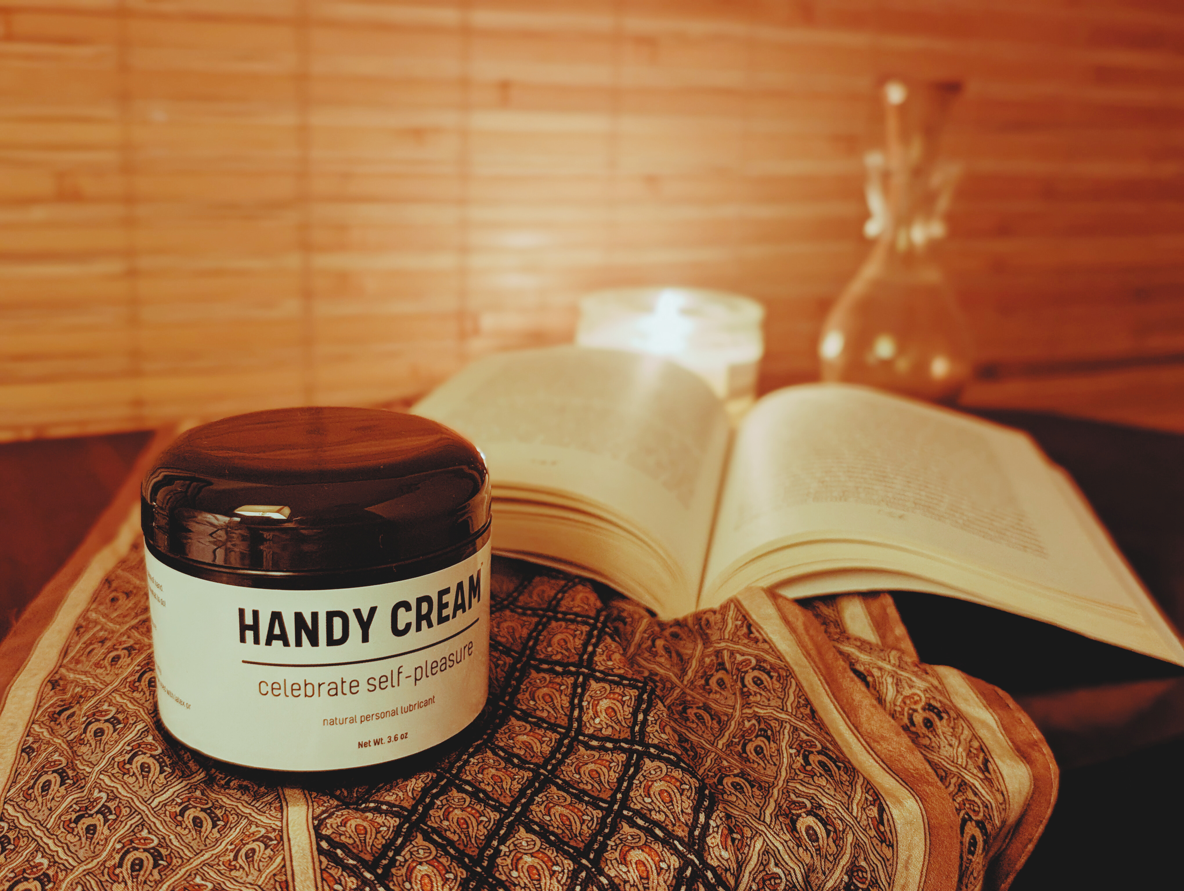 Jar of 'Handy Cream' on nightstand with an open book in the background