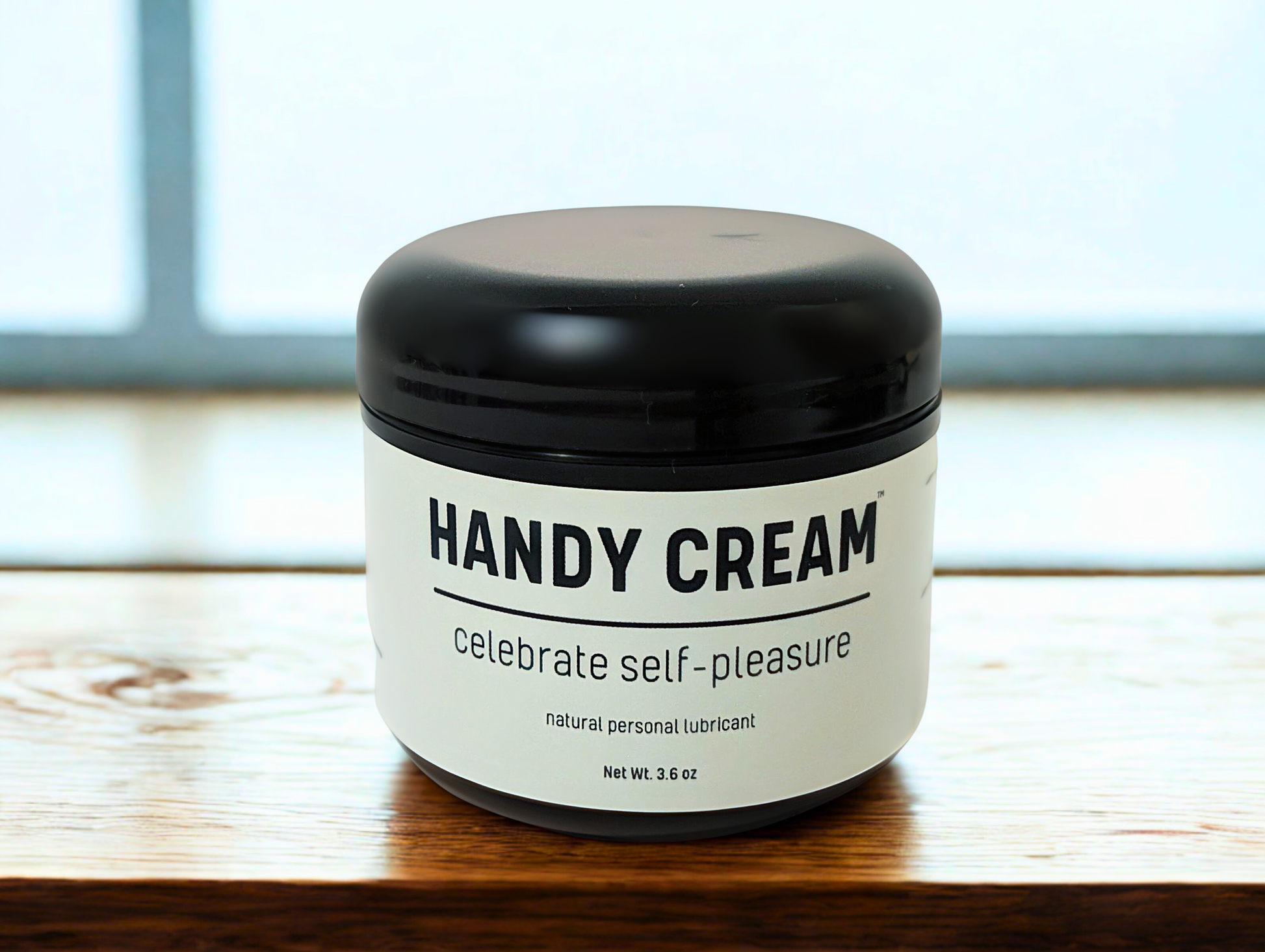 Jar of Handy Cream on a wooden surface with a blurred background